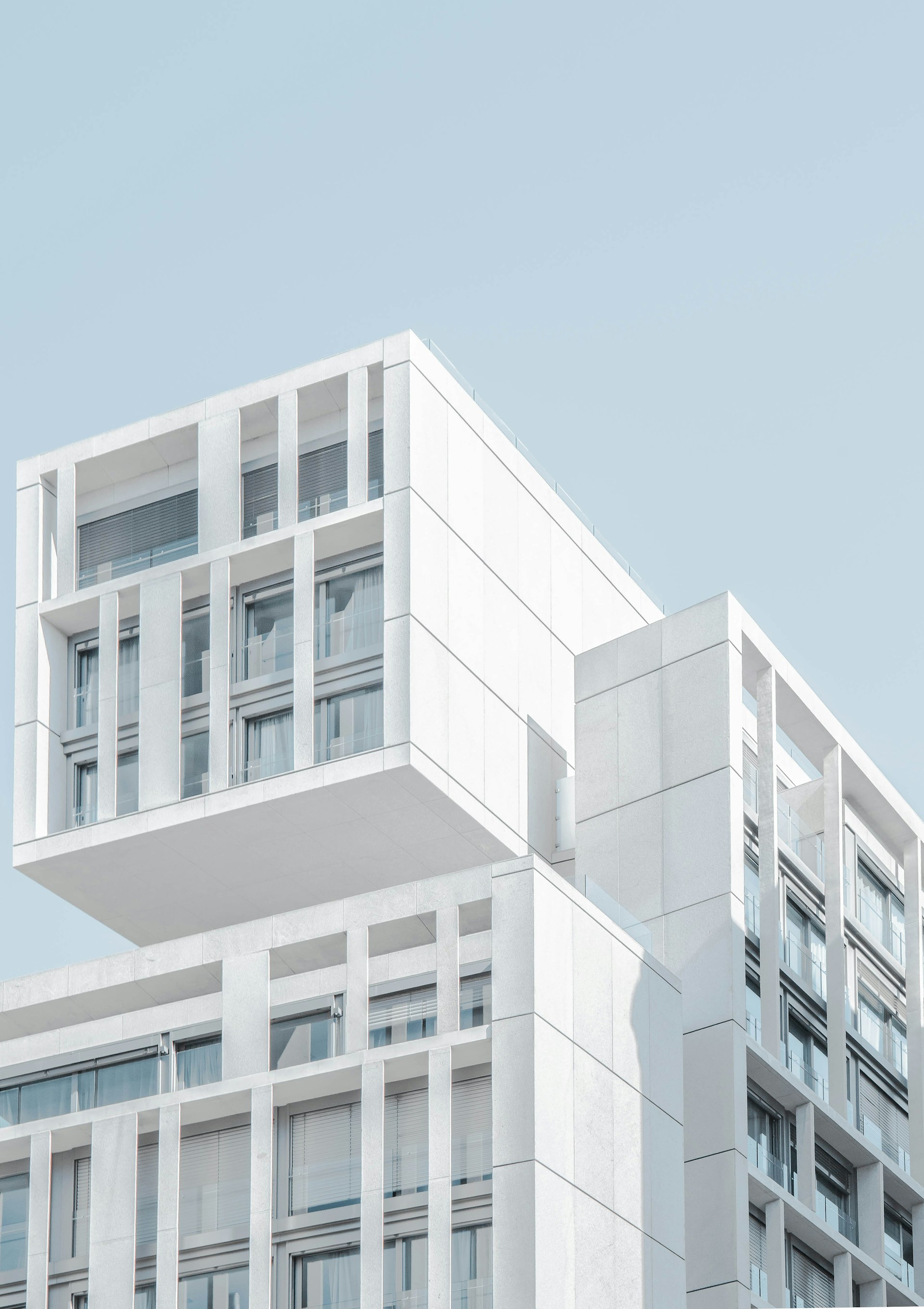 Detail of a modern building facade against a pale blue sky